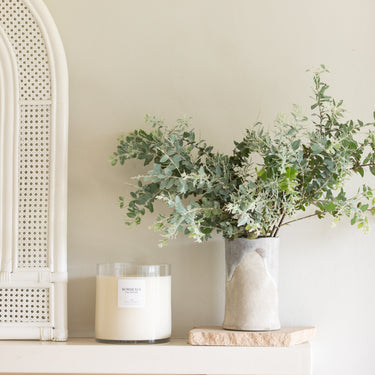 Oversized Candle on fireplace mantle with grenery | Bordeaux Collective